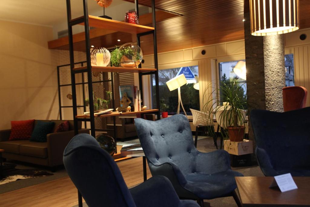 ウールディンゲン・ミュールホーフェンにあるHotel Knaus am Hafenのリビングルーム(青い椅子、テーブル付)