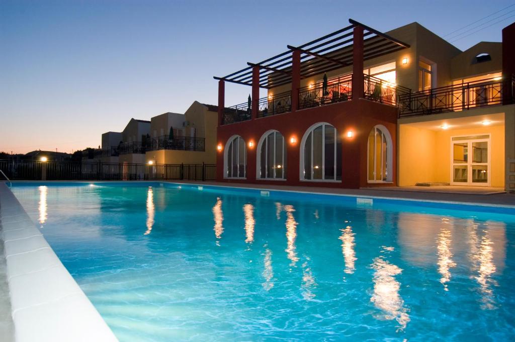 a swimming pool in front of a house at Saint Catherine Hotel in Pythagoreio