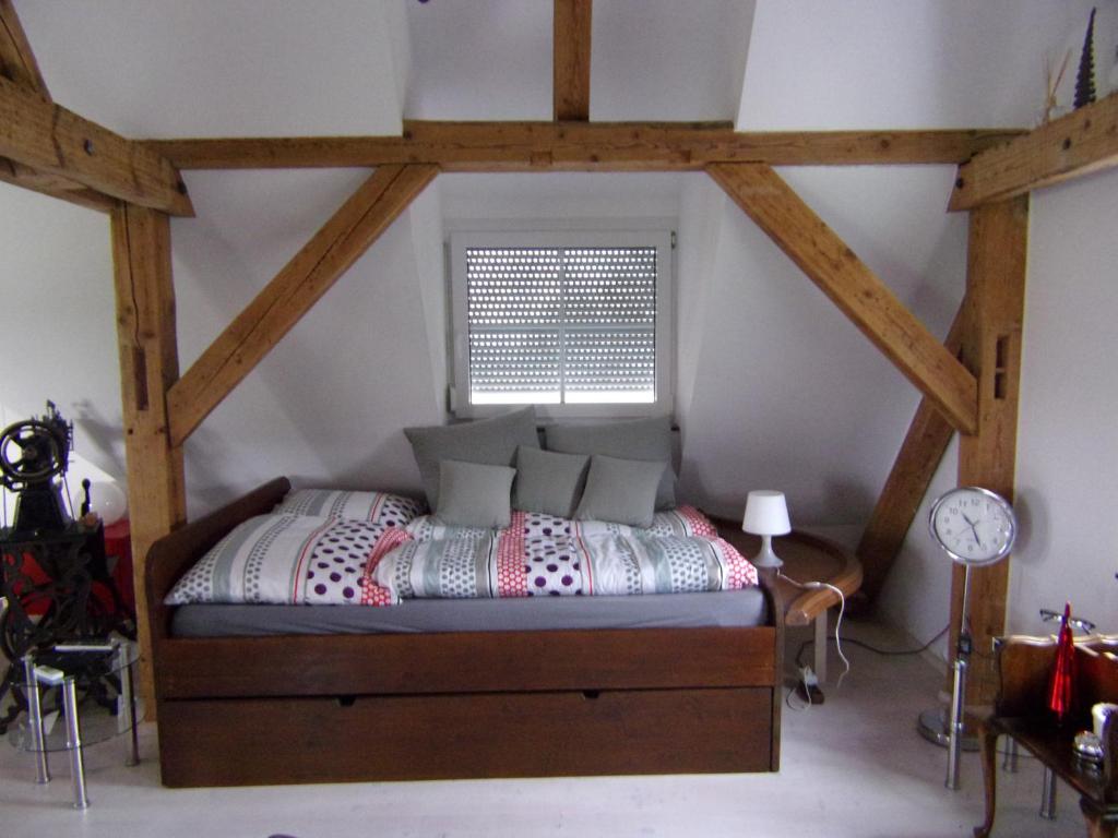 Schlafzimmer mit einem Bett in einem Zimmer mit Holzbalken in der Unterkunft Kleines Schlösschen in Leinau