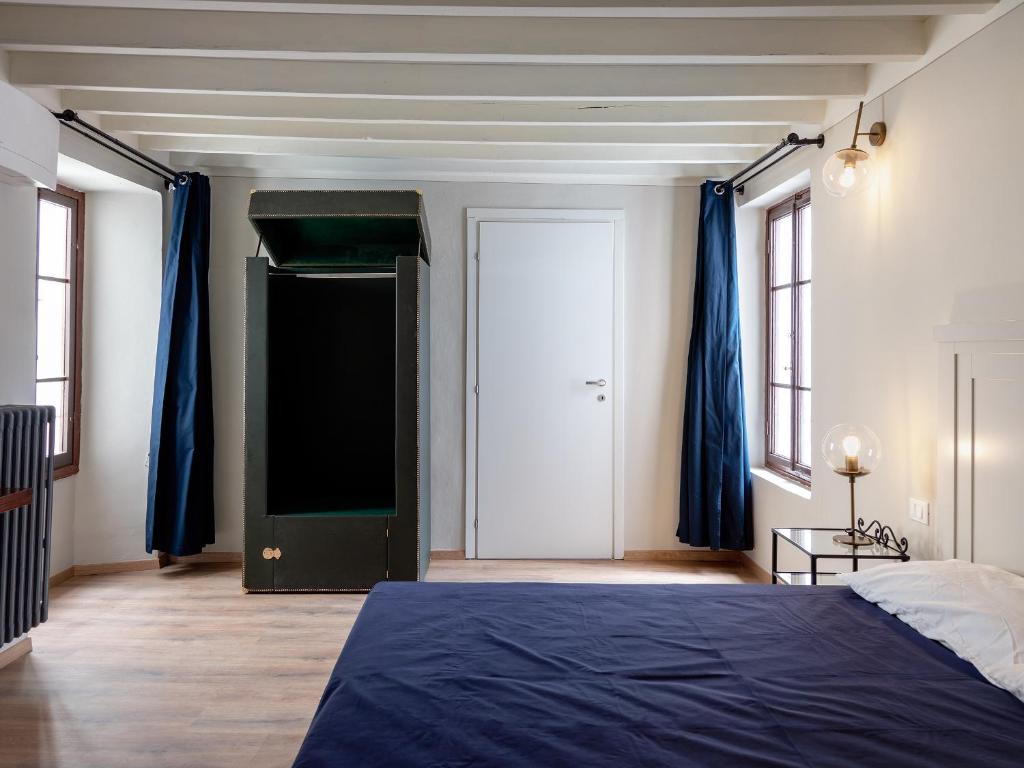 a bedroom with a blue bed and blue curtains at B&B Stupido Hotel in Florence