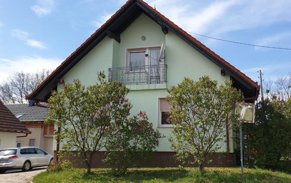 a white house with a balcony on top of it at Beautiful house surrounded by pure nature in Rogašovci