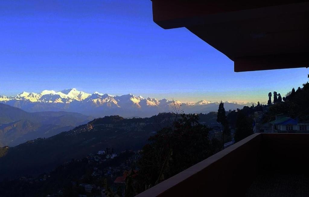 een uitzicht op een bergketen met besneeuwde bergen bij Rambler's Nesting Homestay in Darjeeling