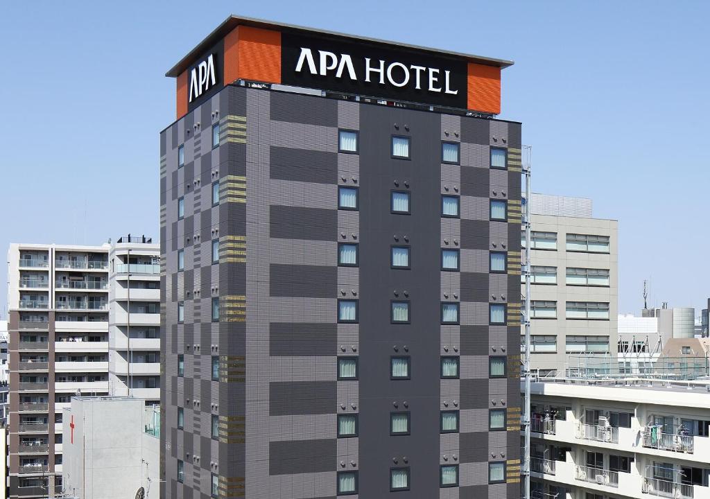 a large building with a large clock on it's side at APA Hotel Ueno Inaricho Ekikita in Tokyo