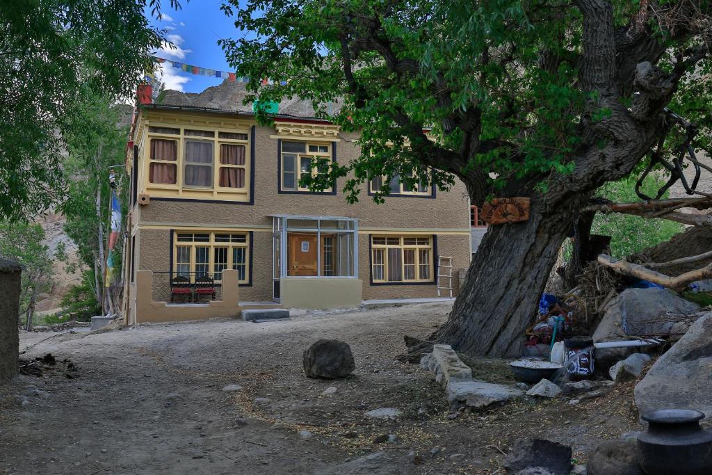 Sumdo saspotse farmstay في Saspul Gömpa: منزل أمامه شجرة