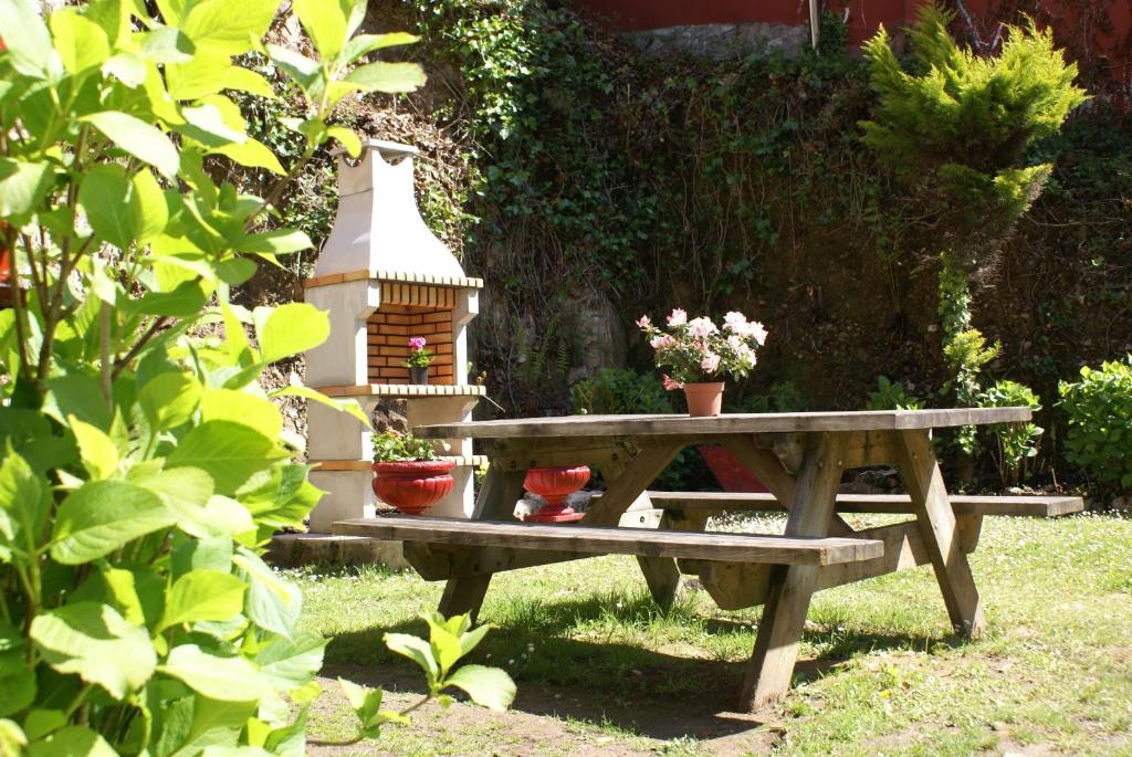 a picnic table with a bird house and potted plants at Casa Rural Priena in Covadonga