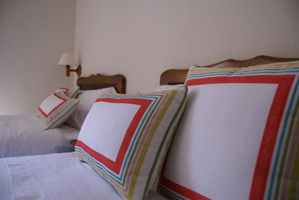 two beds with colorful pillows on them in a bedroom at Casa Rural Priena in Covadonga