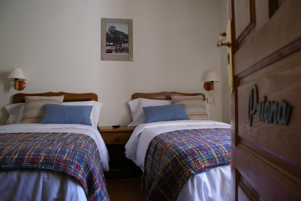 two beds sitting next to each other in a bedroom at Casa Rural Priena in Covadonga