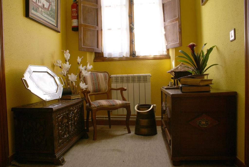 a room with a chair and a table and a window at Casa Rural Priena in Covadonga