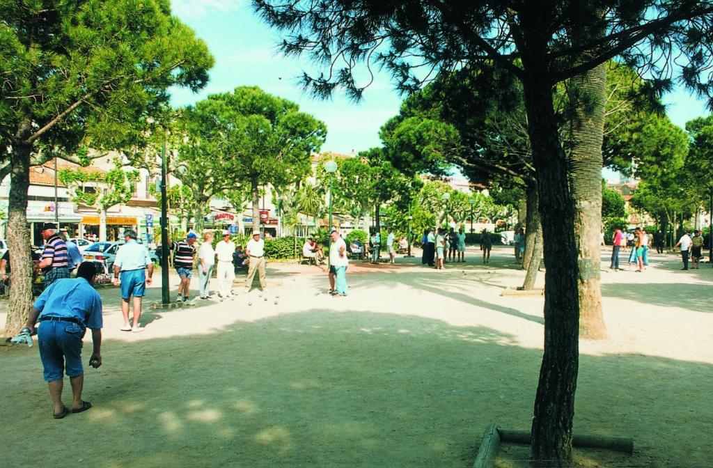 a group of people walking around in a park at Hôtel Lou Paouvadou in Sainte-Maxime