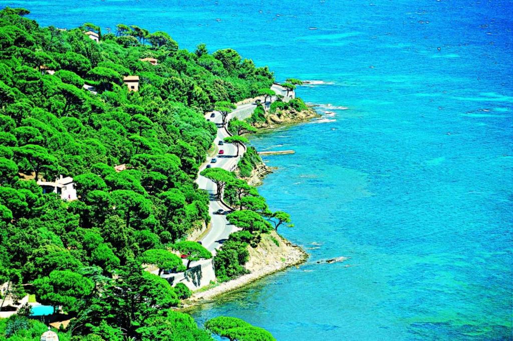 a winding road on a hill next to the ocean at Hôtel Lou Paouvadou in Sainte-Maxime