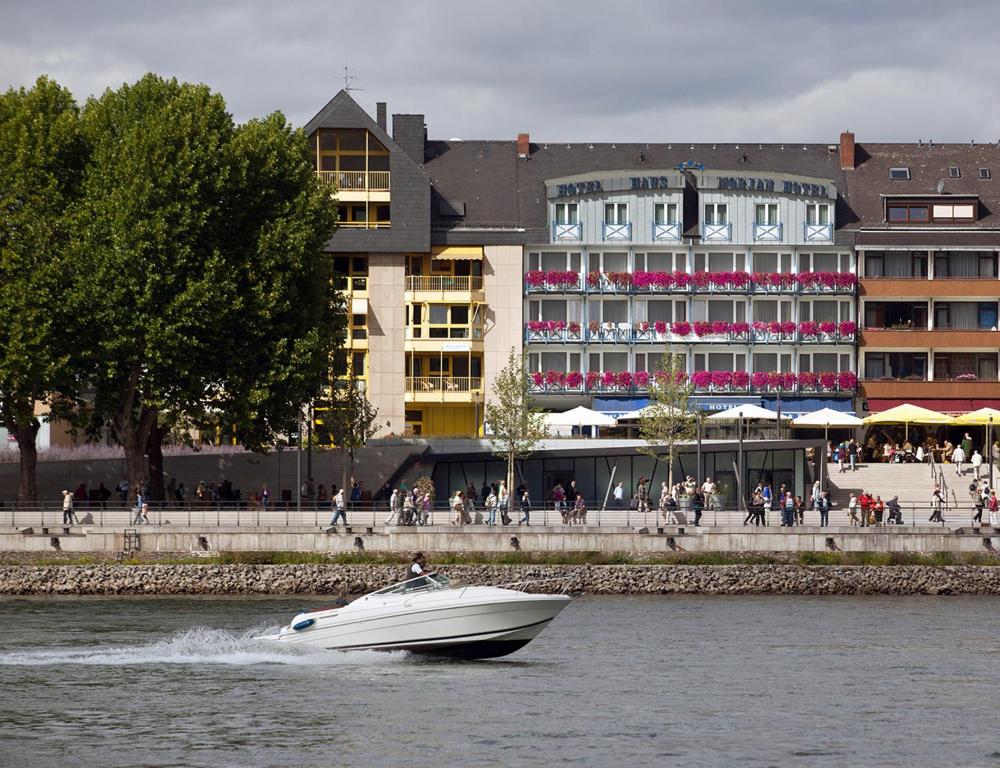 ein Boot im Wasser vor einem Gebäude in der Unterkunft Hotel Morjan in Koblenz