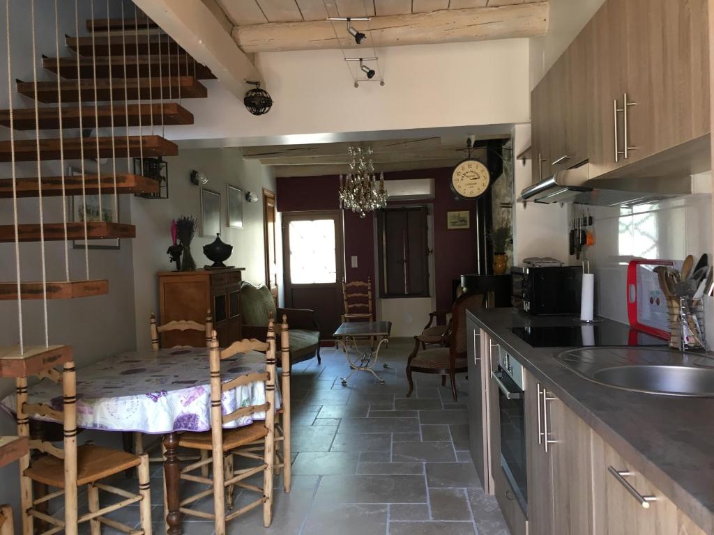 a kitchen with a counter and a table with chairs at La maussanaise in Maussane-les-Alpilles