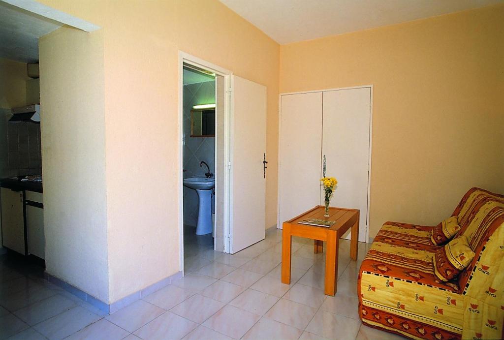 a living room with a couch and a table at Hôtel Lou Paouvadou in Sainte-Maxime