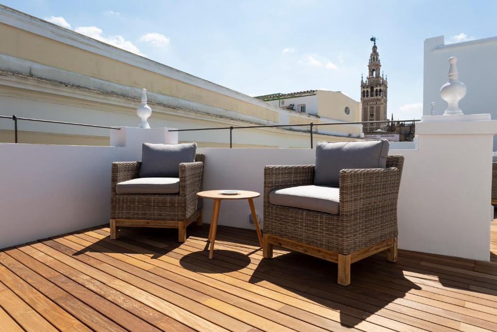 2 sillas y una mesa en el balcón en Basic Hotel Sevilla Catedral, en Sevilla