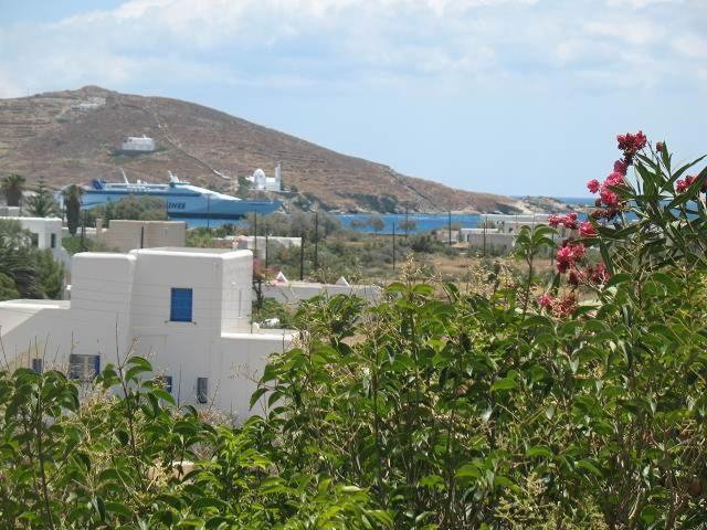 a group of white buildings with a mountain in the background at Vesuvio Kampos in Ios Chora