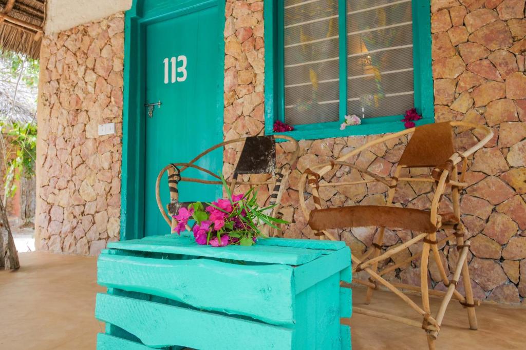 a blue cabinet with flowers on it and a chair at Demani Lodge Zanzibar in Paje