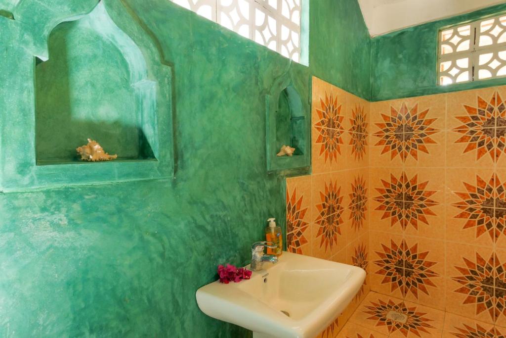 y baño con lavabo y espejo. en Demani Lodge Zanzibar en Paje