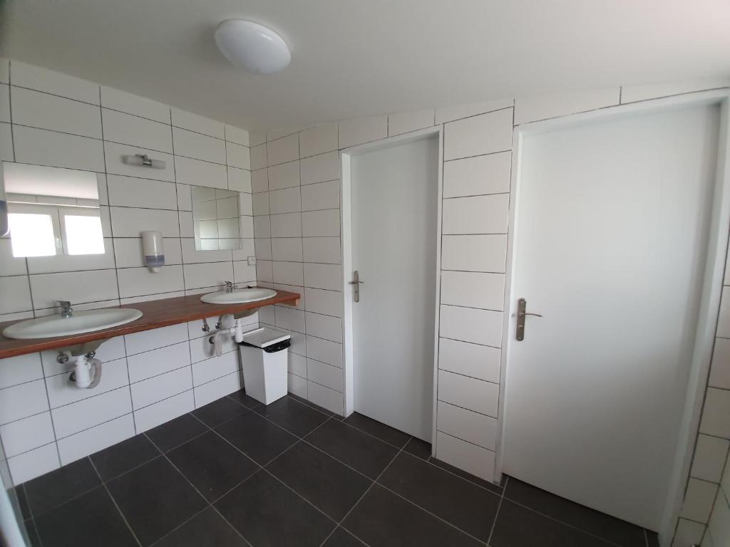 ein Badezimmer mit zwei Waschbecken und zwei Spiegeln in der Unterkunft Olivin Kytlice Hiker Huts in Kytlice