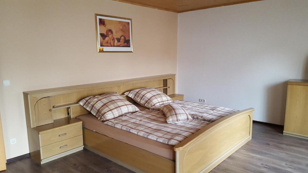 1 dormitorio con cama de madera y almohadas en Zeit(t)raum Mandy in Brandy, en Waldsolms