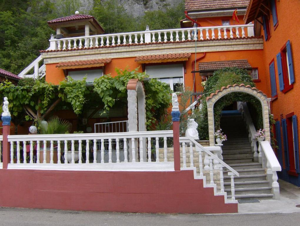 une maison orange avec une balustrade blanche et des escaliers dans l'établissement Hotel-Restaurant Don Pepe, à Kleinlützel