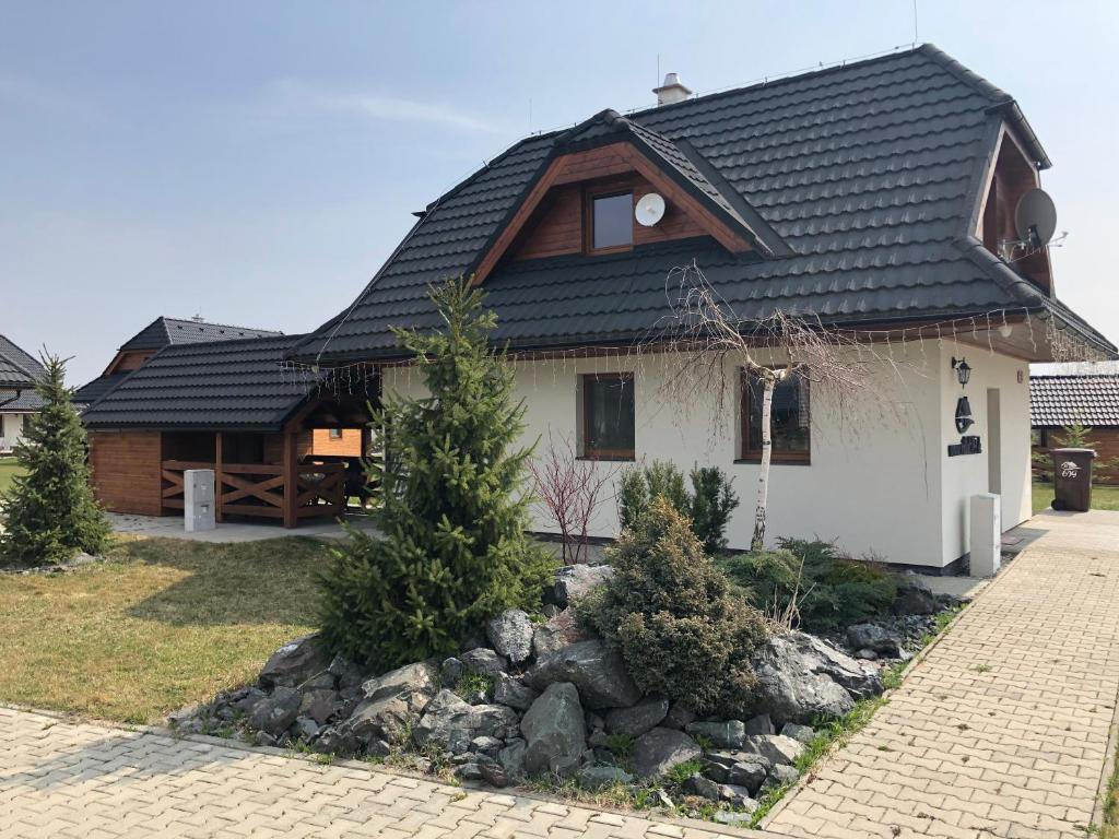 a house with a black roof and a rock garden at VILLA 619 in Stará Lesná