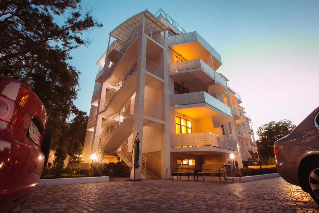 un gran edificio blanco con escaleras en el lateral en Art Hotel KOKTEBEL APARTMENTS, en Koktebel