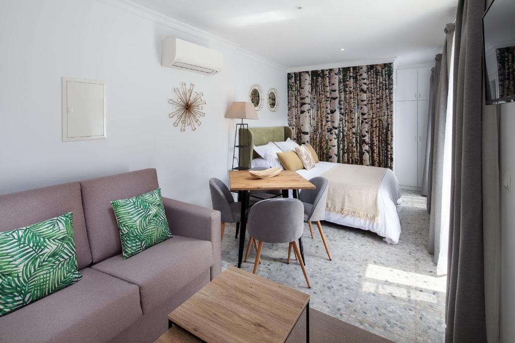 sala de estar con sofá y cama en Wanderlust Malaga Apartamentos Atico, en Málaga