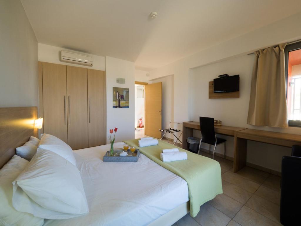 1 dormitorio con 1 cama blanca grande y escritorio en Almyra Hotel, en Karfas