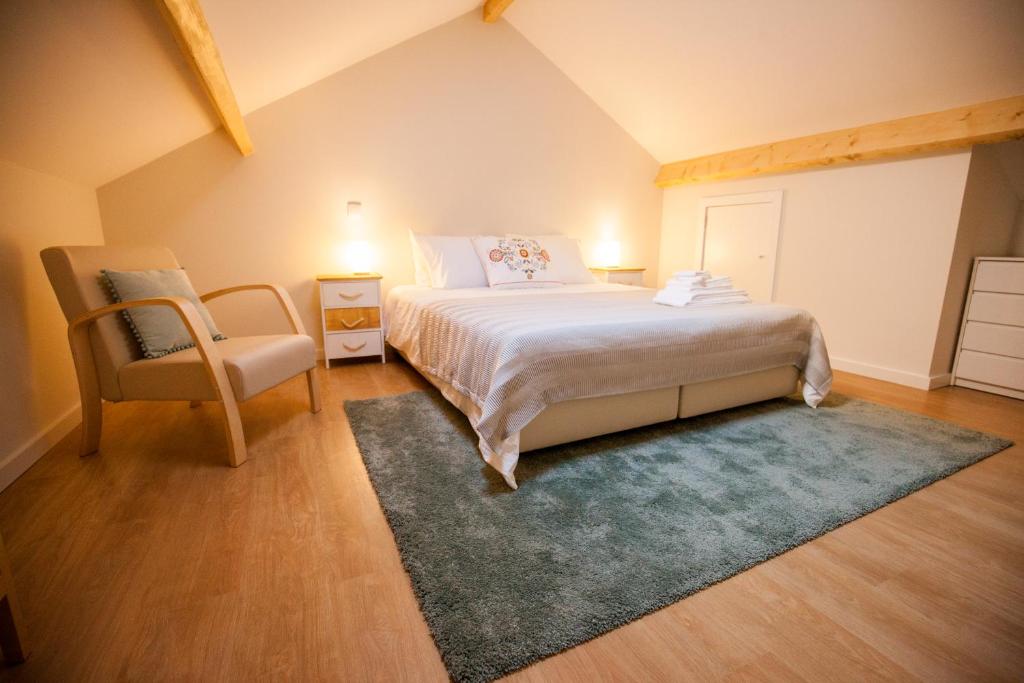 1 dormitorio con 1 cama grande y 1 silla en OportoWaves, en Matosinhos