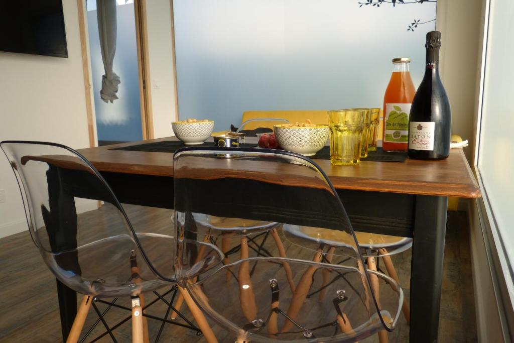 une table avec deux chaises et deux bouteilles de vin dans l'établissement l’Inattendu, à Vannes
