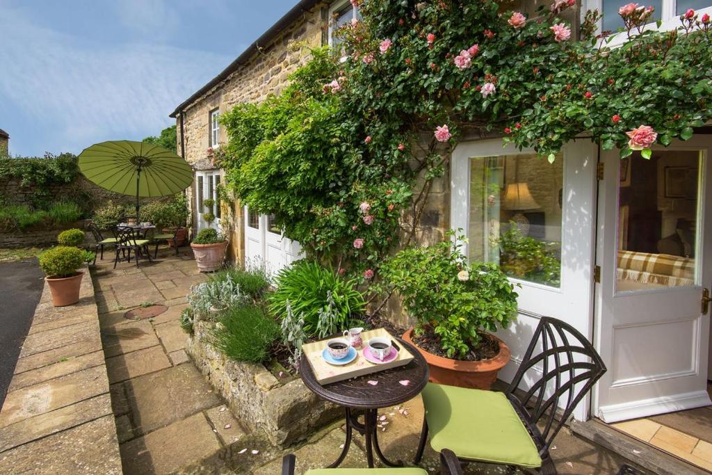 a patio with a table and chairs in front of a building at Middle Cottage Southlands Farm in Gunnerton