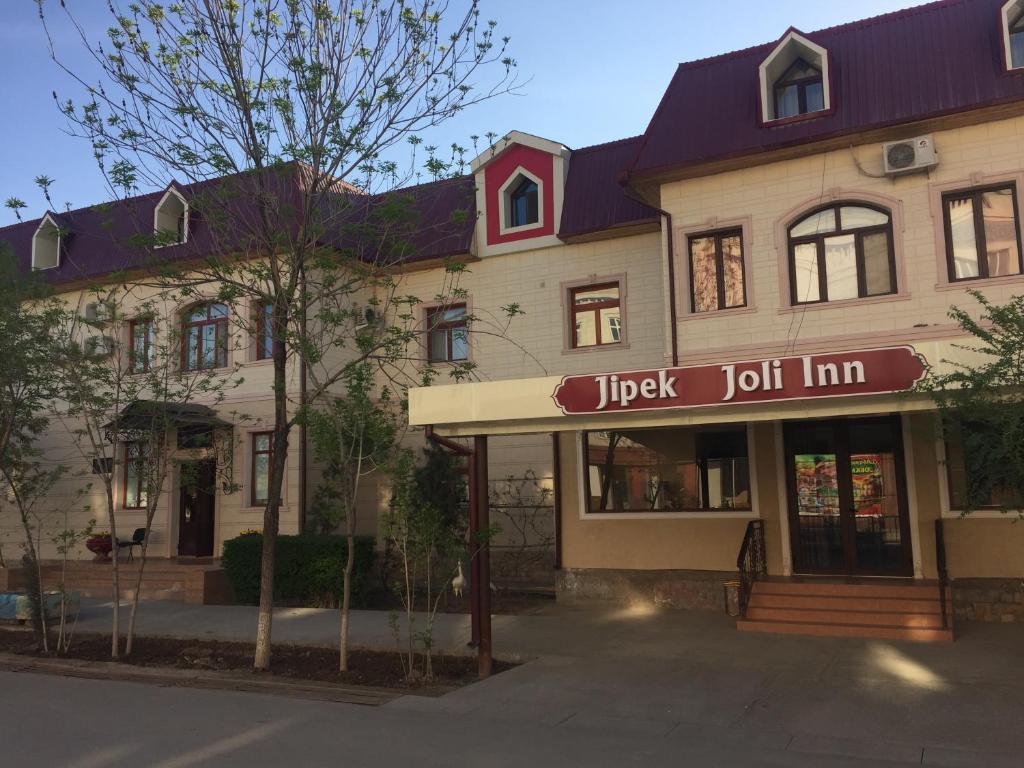 ein Gebäude mit einem Schild, das ein glückliches Gasthaus liest in der Unterkunft Jipek Joli Inn in Nukus