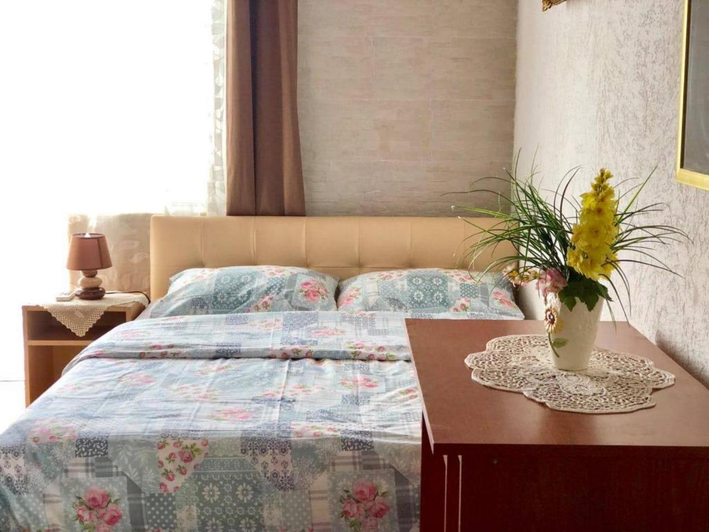 a bed with a table with a vase on it at Apartments Zuto in Ulcinj