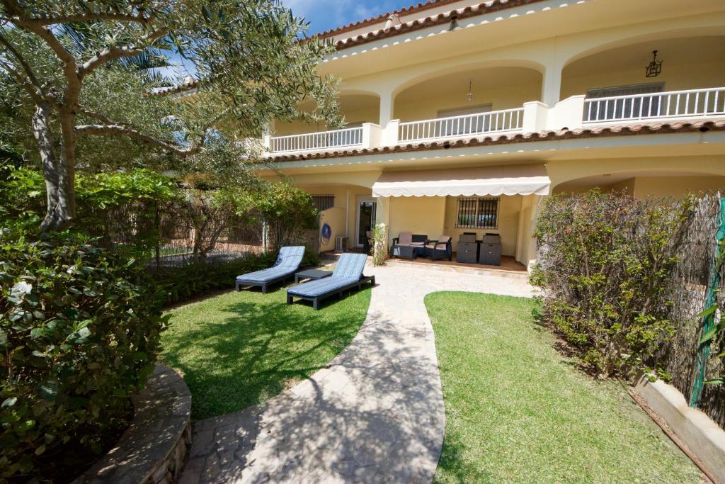 a house with a patio with two couches in the yard at El Olivo in L'Ampolla