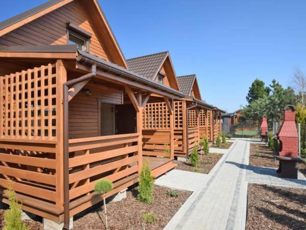 a row of wooden lodges with a pathway in front at Domki u Górali in Wicie