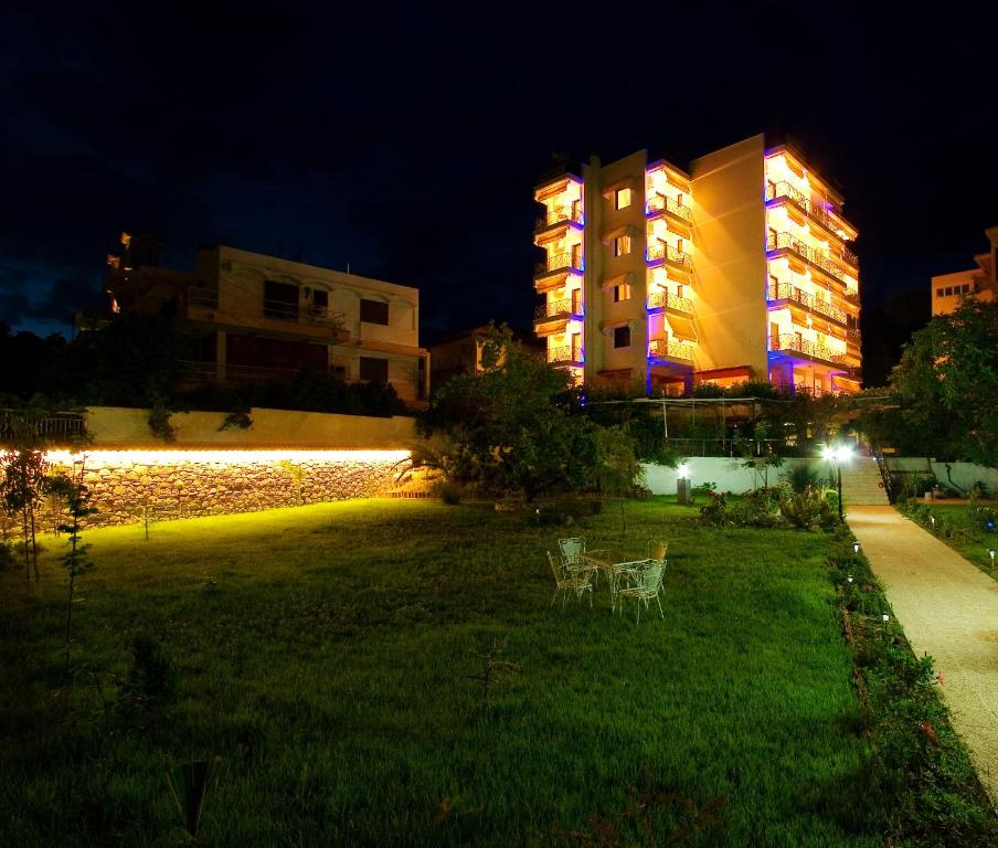 a building with two chairs in the grass at night at Sagini Boutique Hotel in Loutra Edipsou