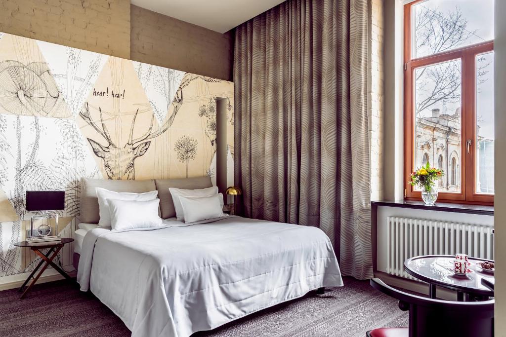 um quarto com uma cama branca e uma janela em Boutique Hotel Villa Perlov em São Petersburgo