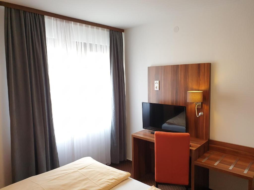 TV a/nebo společenská místnost v ubytování Kirchberg Hotel garni