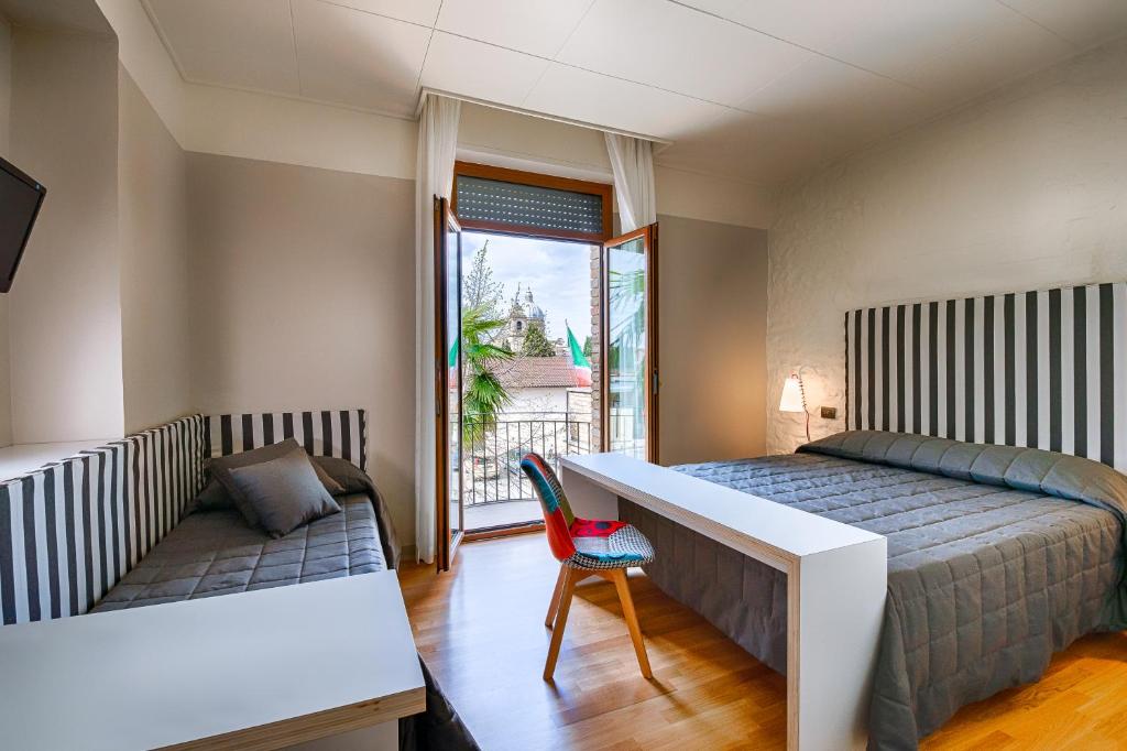 sypialnia z łóżkiem, biurkiem i oknem w obiekcie Hotel Moderno w Asyżu