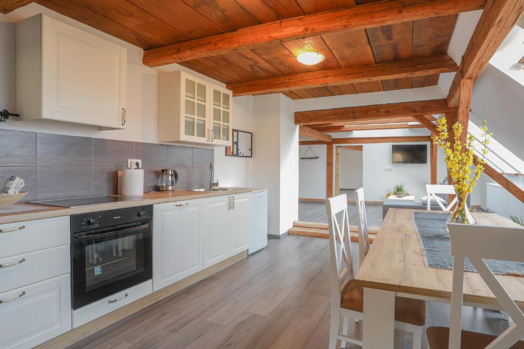 uma cozinha com armários brancos e uma mesa de jantar em Apartment Krnicar em Zgornje Gorje