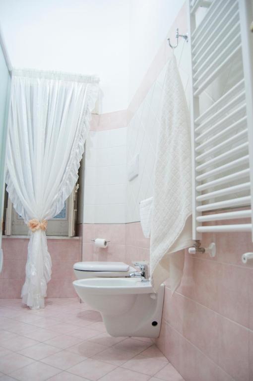 łazienka z toaletą i białą zasłoną w obiekcie B&B Villa Roma w mieście Piazza Armerina