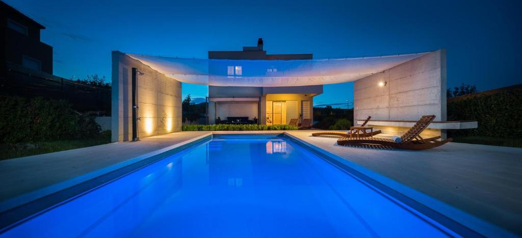 una piscina di fronte a una casa di notte di Luxury villa Wisdom near Split, private pool a Dugopolje (Dugopoglie)