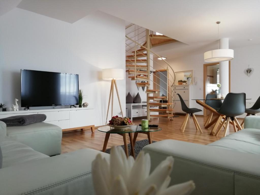 uma sala de estar com 2 sofás e uma televisão de ecrã plano em Ferienwohnung Prestige 1 em Friedrichshafen