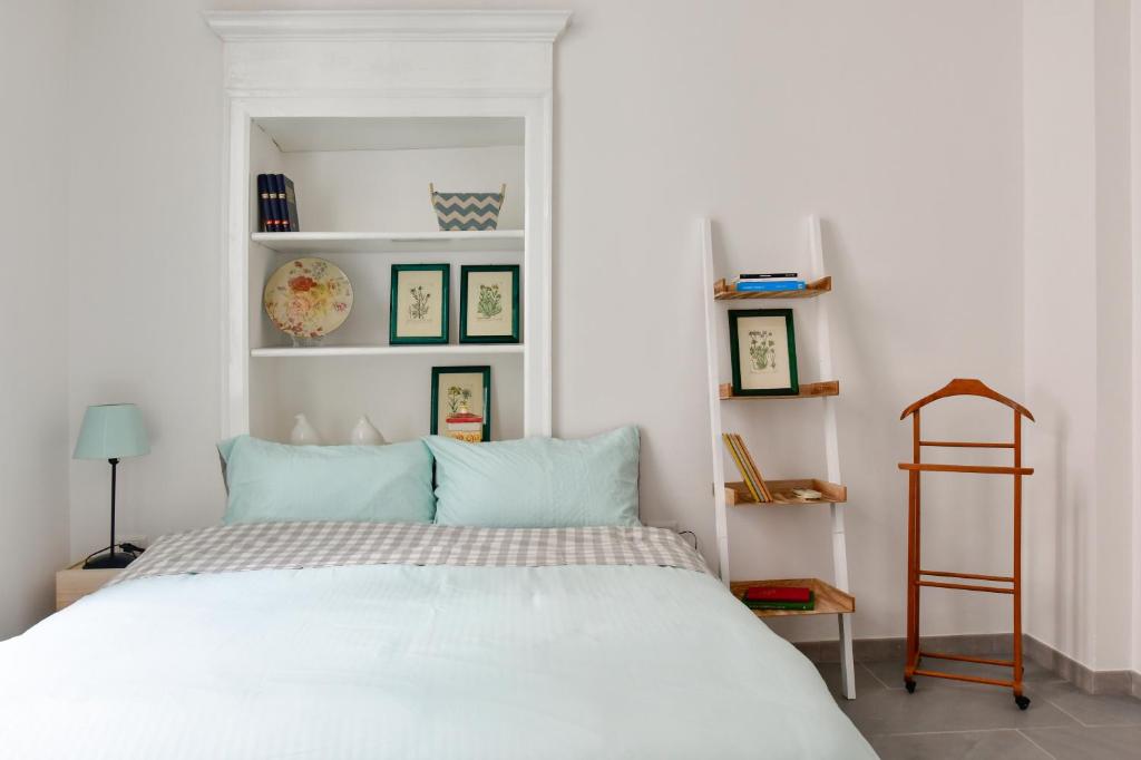 1 dormitorio con 1 cama blanca grande con almohadas azules en Casa Cavour - Luxury Apartment, en Sassari