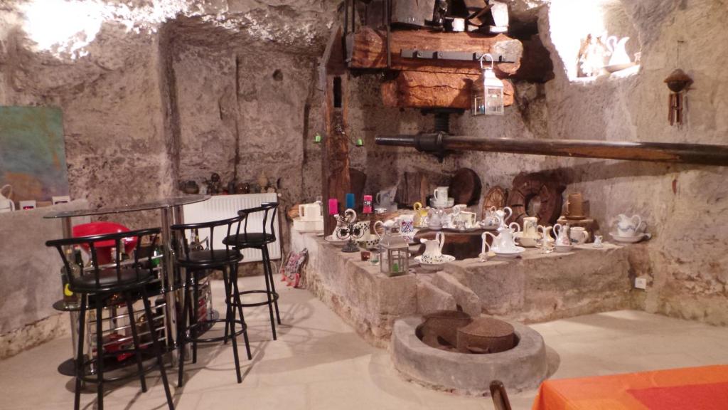 a room with a table and chairs in a room at maison troglodyte in Pocé-sur-Cisse