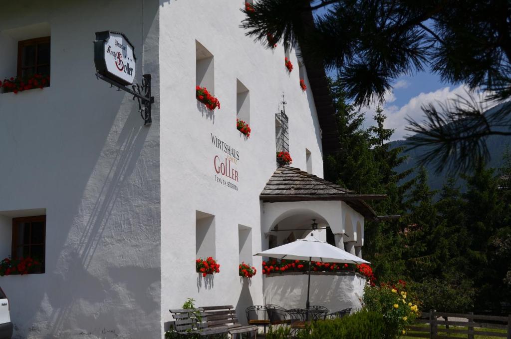 een wit gebouw met een prieel en een klok bij Ansitz Goller in Rasun di Sopra