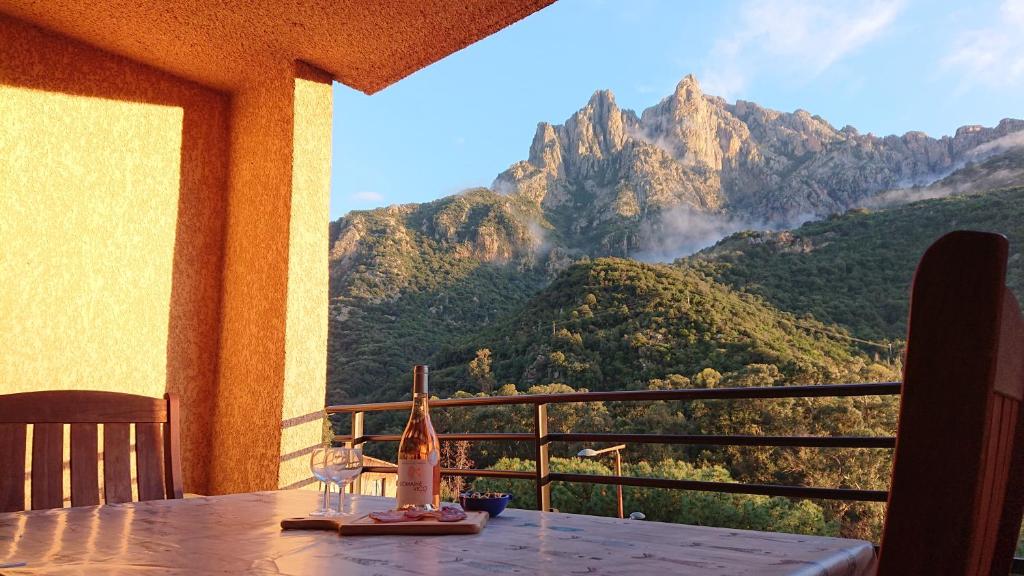 a table with wine glasses and a view of a mountain at Résidence A Barcella in Porto Ota