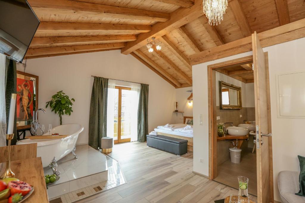 ein Bad mit Badewanne und ein Bett in einem Zimmer in der Unterkunft Landhaus Wiesner - Gästezimmer - Bad - Bett - Kleine Kaffee - Tee-Theke mit Kühlschrank - Parkplatz in Rottach-Egern