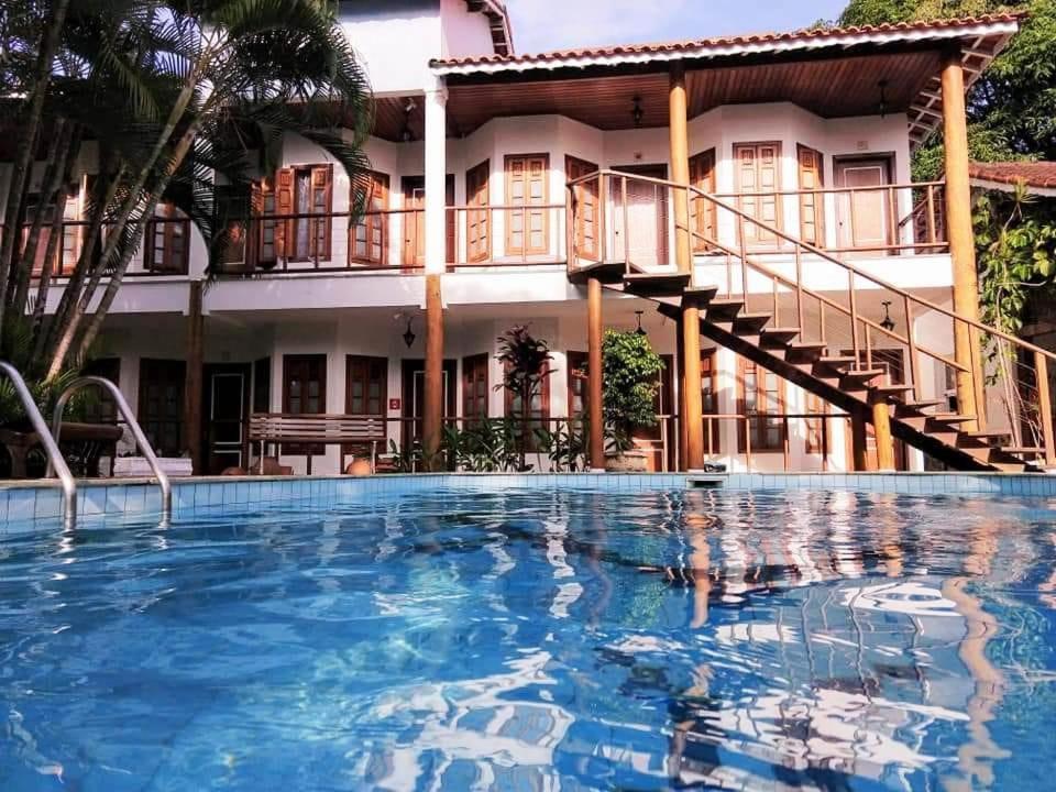 un hotel con piscina frente a un edificio en Pousada Náutilus, en Ilhabela