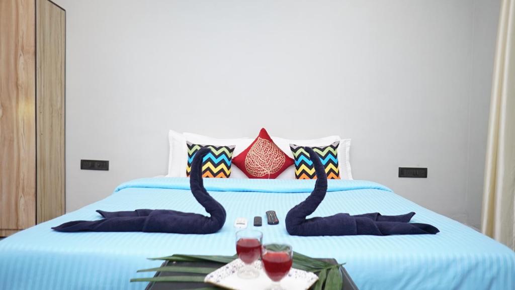 ein Bett mit zwei schwarzen Schwänen drauf mit Weingläsern in der Unterkunft Aroma boutique villa by 29 Bungalow in Nagaon